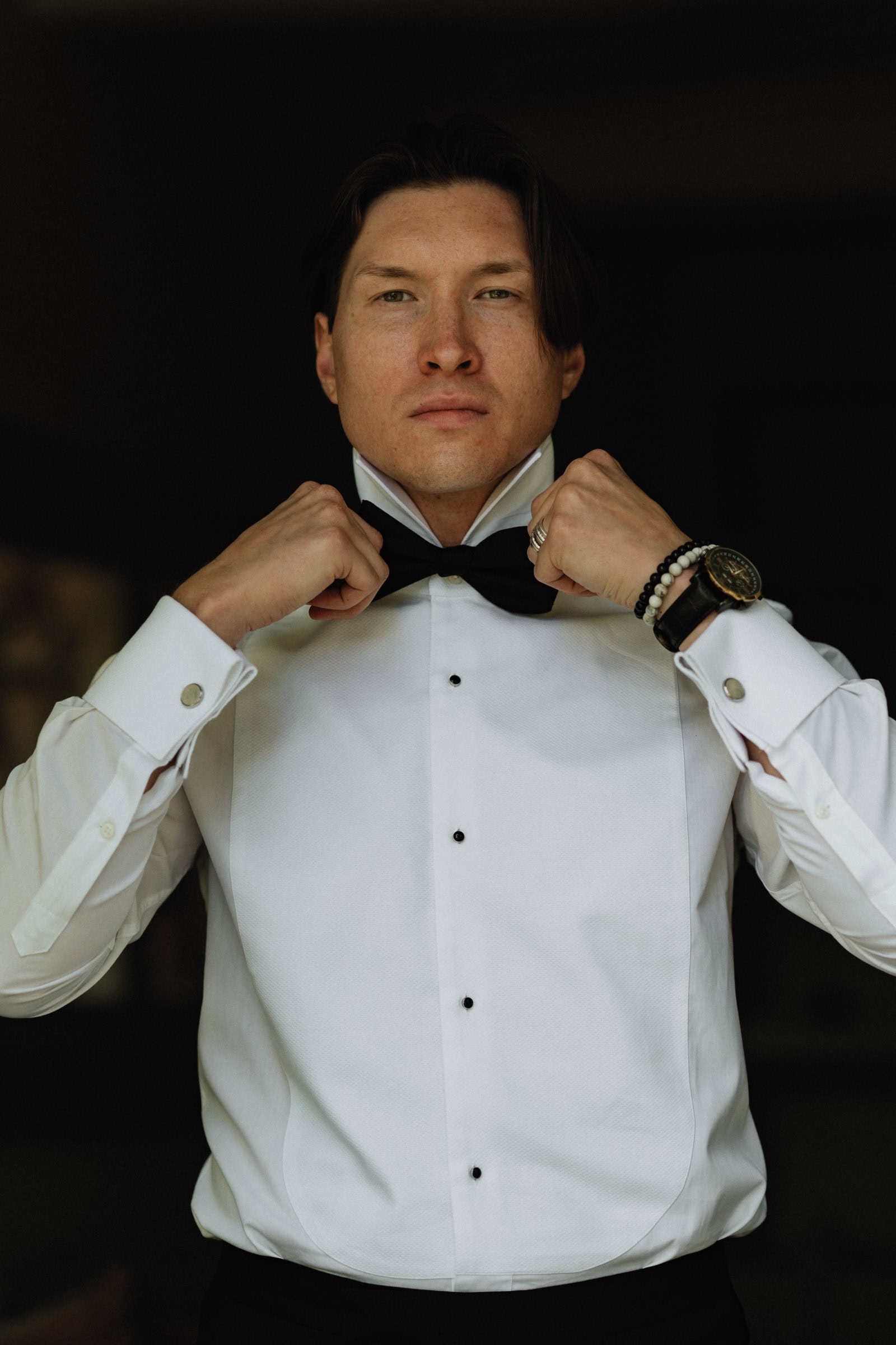 Bräutigam richtet Fliege vor der Hochzeit in der Toskana