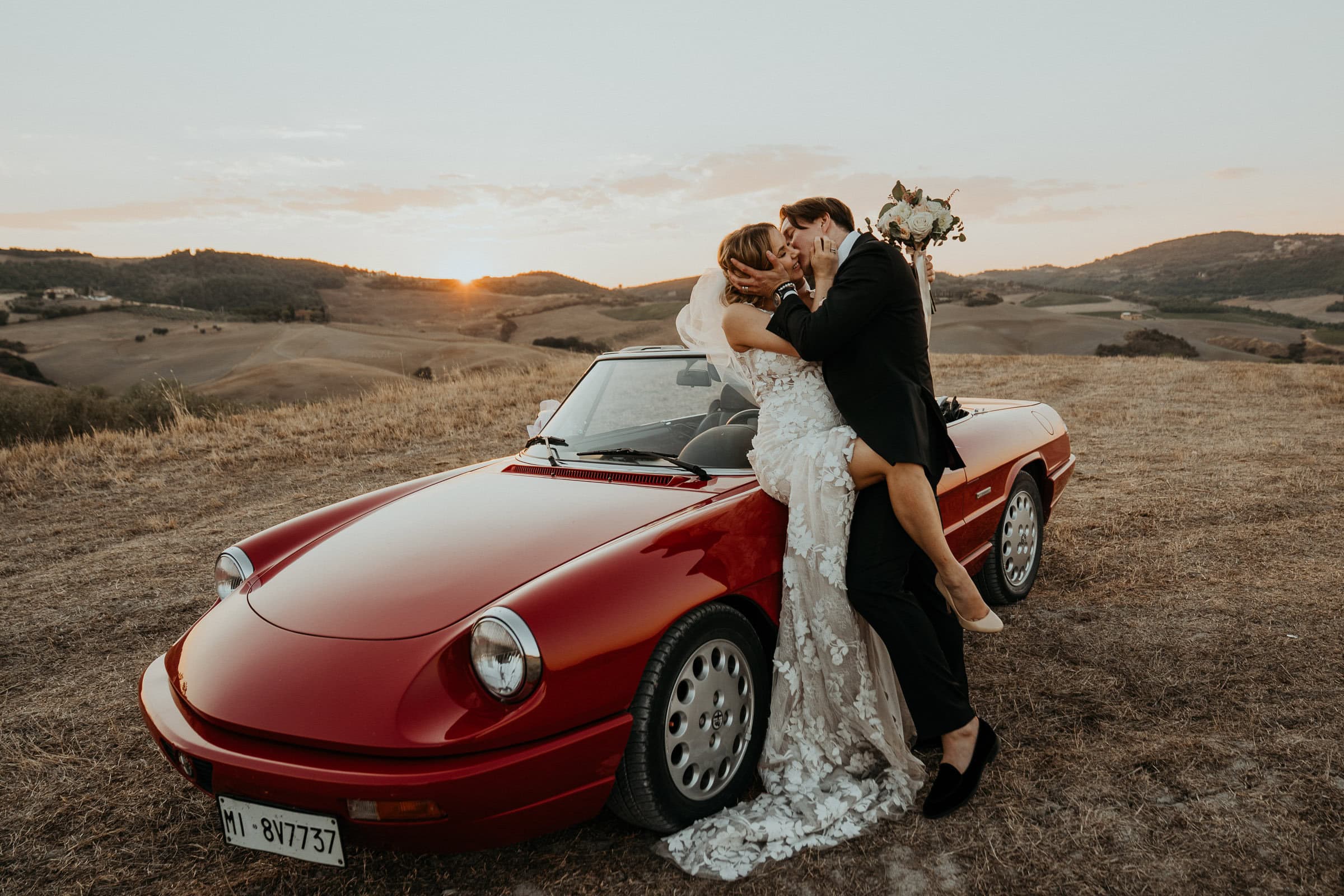 Paar lehnt sich am Auto in den Hügeln der Toskana